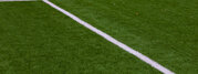 Photo of a green synthetic grass sports field with white line shot from above
