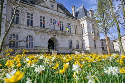 PHoto de l'hôtel de Ville avec des fleurs au premier plan